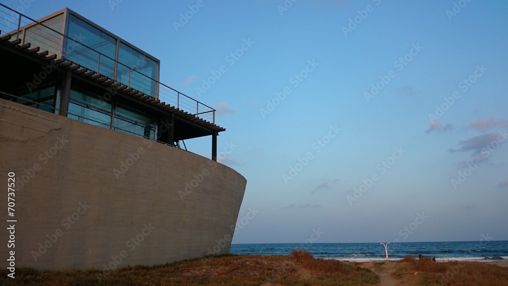 Fototapeta premium Edificio con forma de barco junto al mar