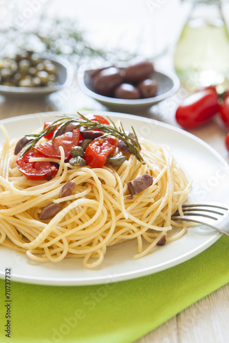 italian spaghetti pasta with cherry tomatoes, olives, capers and