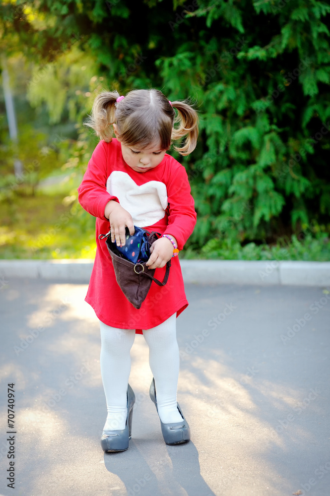 Fototapeta premium Little girl with handbag in park