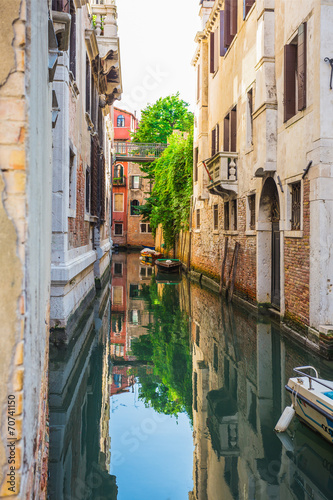 Narrow canal among old colorful brick houses in Venice © Oleg Zhukov