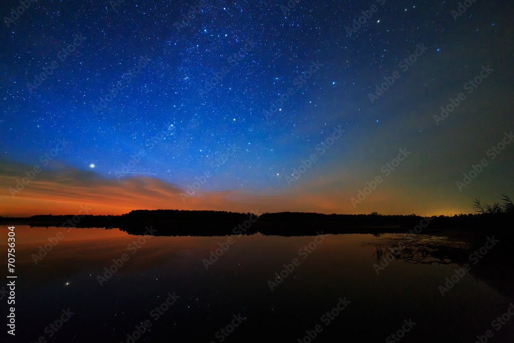 Morning dawn on a starry background sky reflected in the water o Morning dawn on a starry background sky reflected in the water o