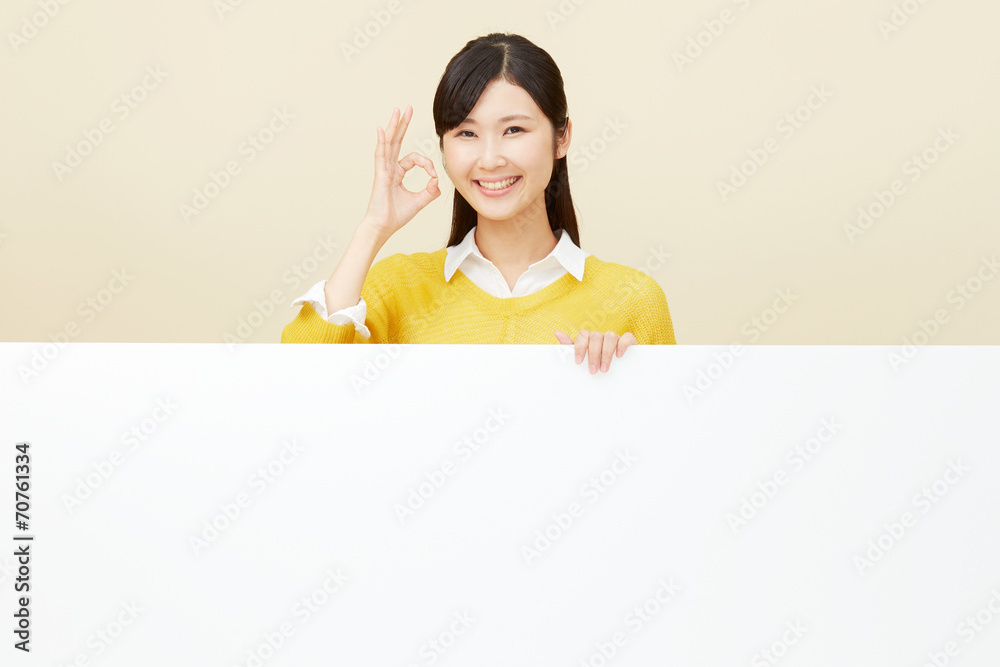 メッセージボードとOKサインする女性