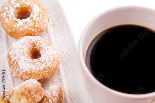 A mug of coffee and homemade doughnut with sugar toppings 