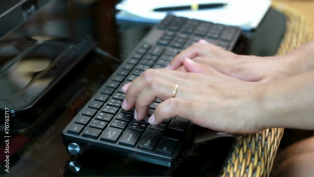 Close up of a young woman typing on a laptop keyboard