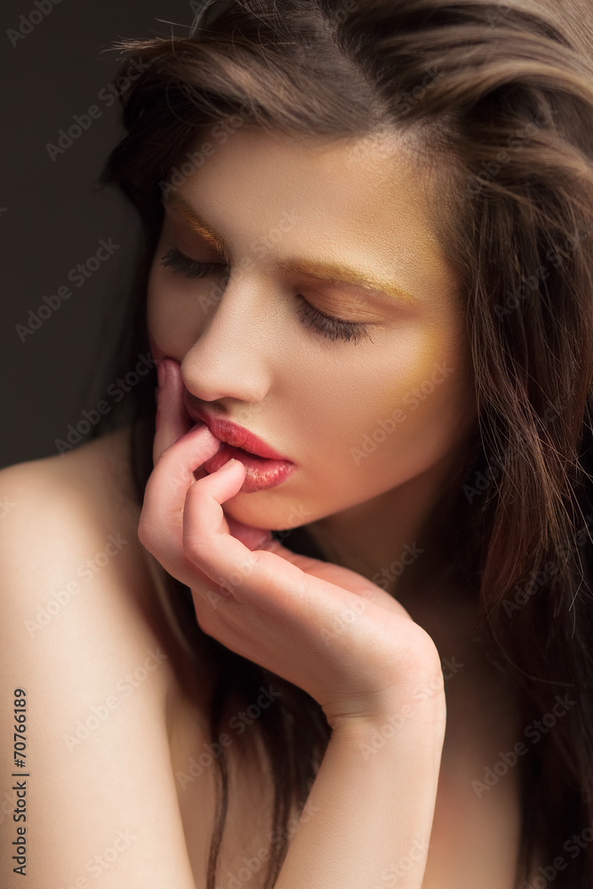 girl with a golden makeup and black background girl with a golden makeup and black background