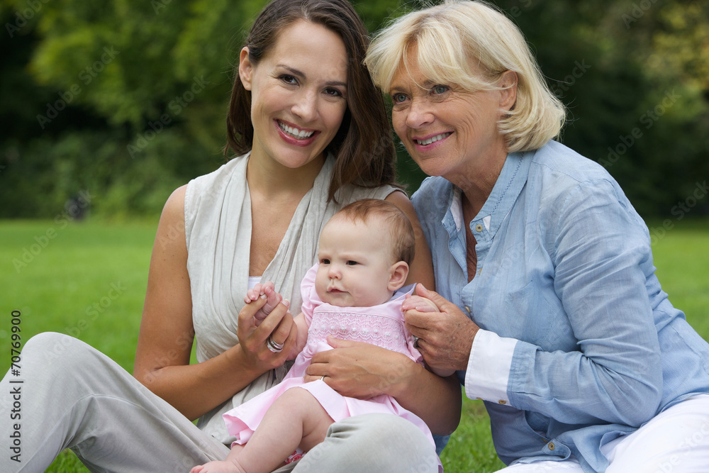 Smiling mother with child and grandmother outdoors