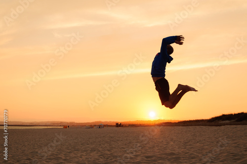 Man silhouette. Jumping in the beach at sunset