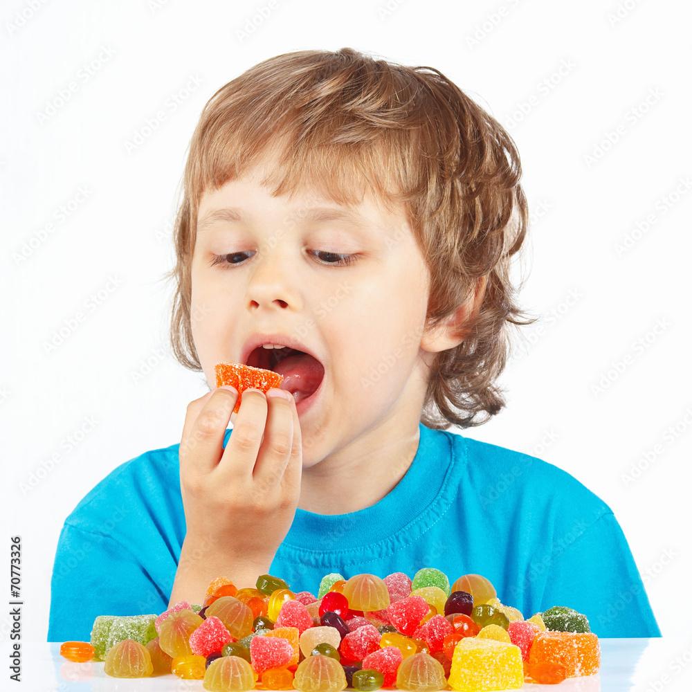 Little child eating jelly candies on a white background Little child eating jelly candies on a white background