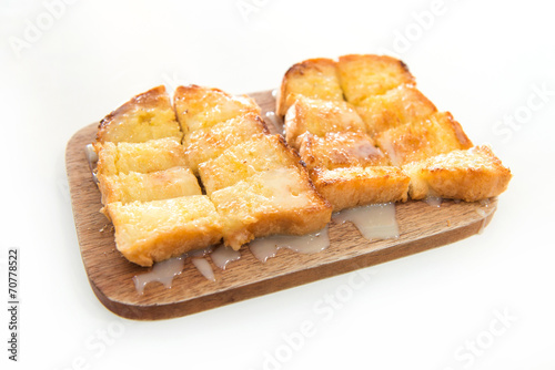 Bread toast and condensed milk on wooden plate