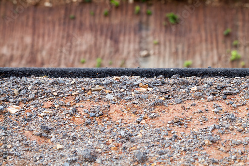 Cross section of asphalt road with rock background.