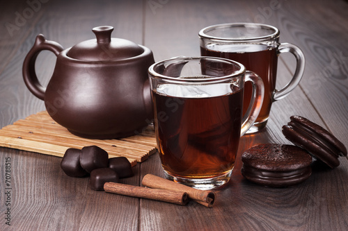 cup of tea with cinnamon sticks and teapot on the table