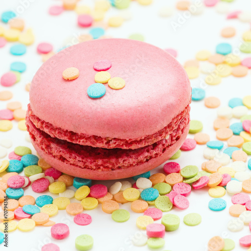 Pink macaroon against colorful background.