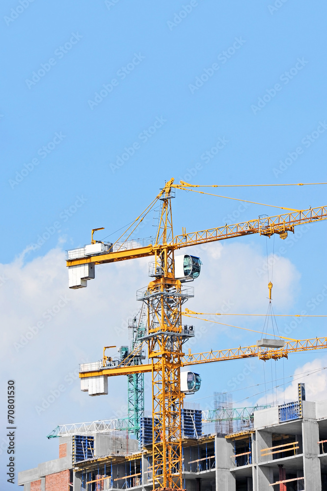 Crane and building construction site against blue sky Crane and building construction site against blue sky