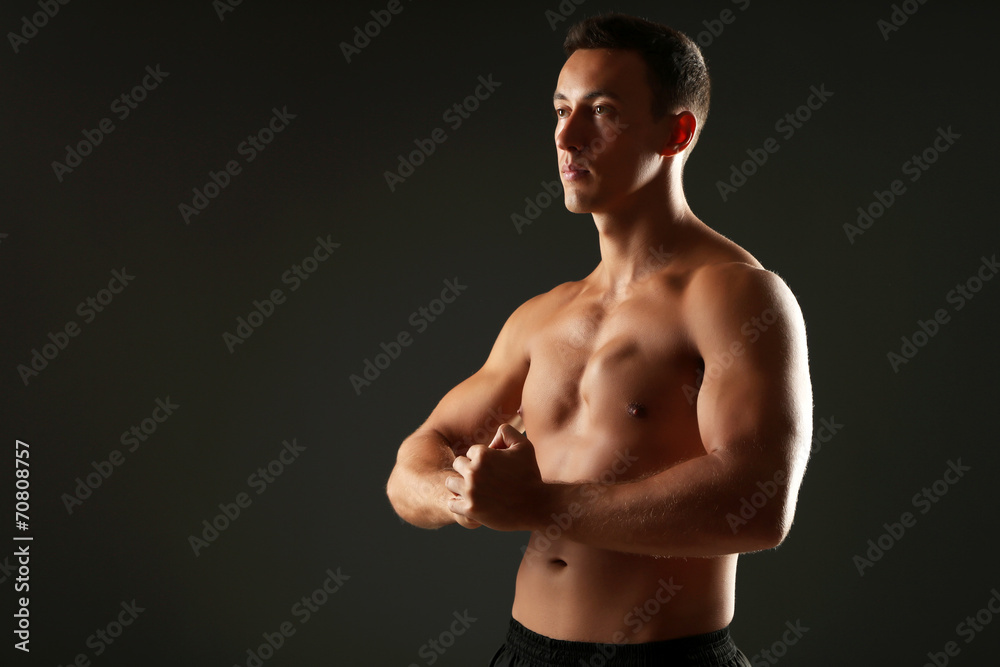 Fototapeta premium Handsome muscle young man on dark background