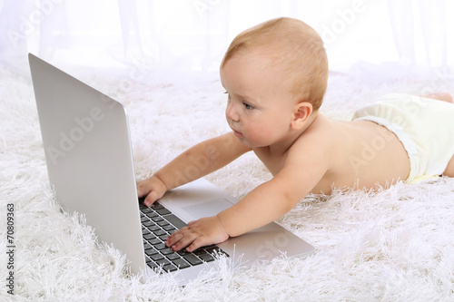Cute baby boy with laptop o...