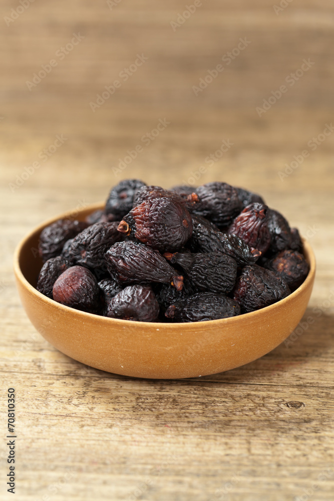 Black dried figs on a wooden surface Black dried figs on a wooden surface
