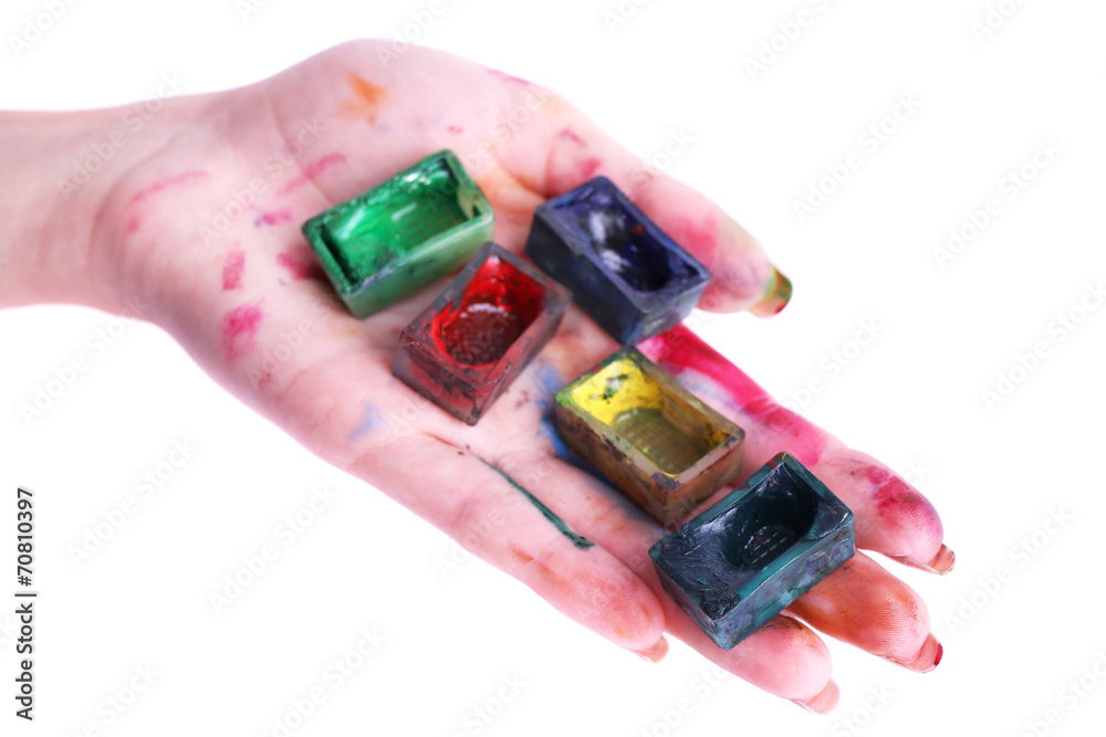 Watercolor paint cubes in female hand isolated on white