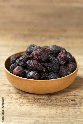 Black dried figs on a wooden surface