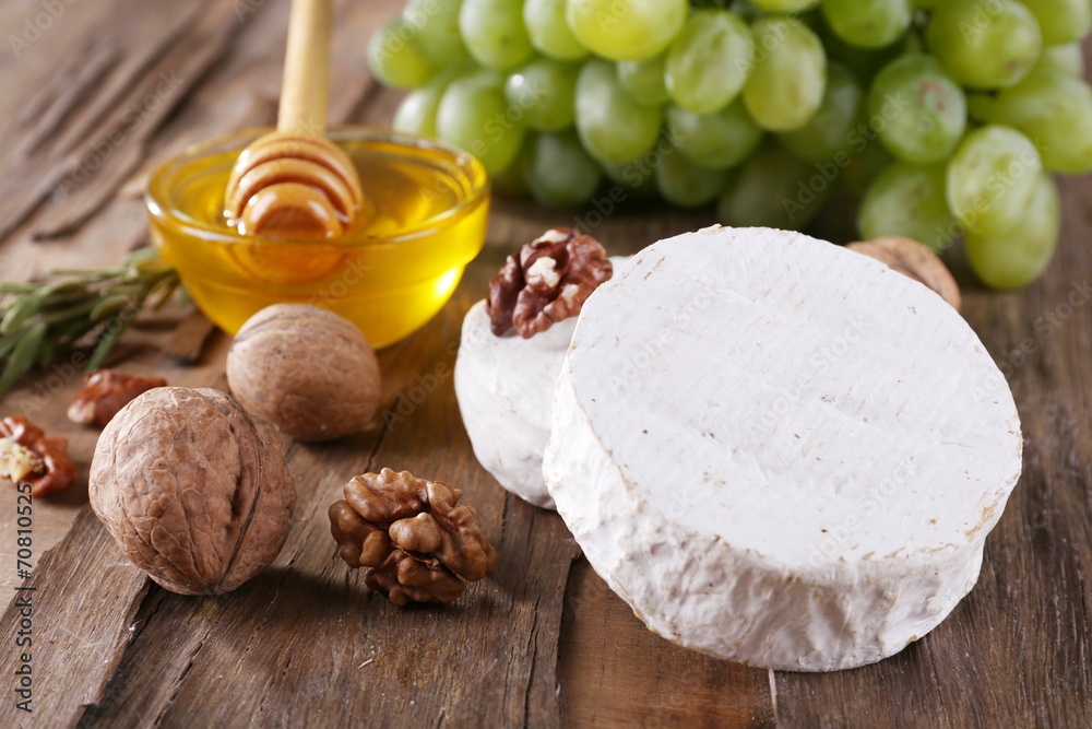 Fototapeta premium Camembert cheese, nuts, grapes and honey in glass bowl
