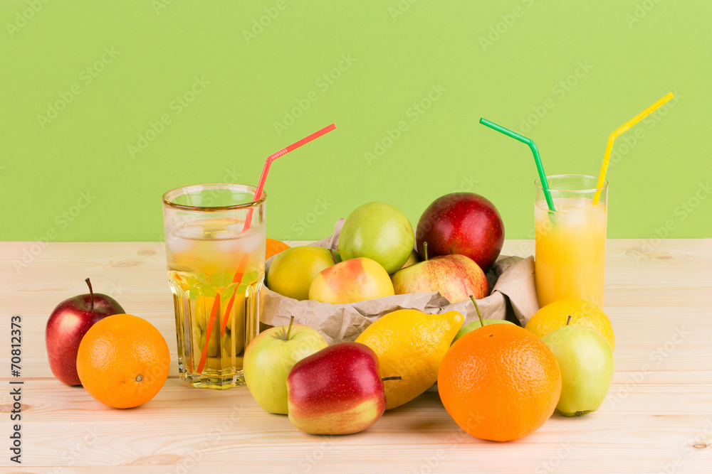Orange and apple juices on wooden table.