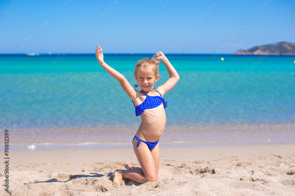 Adorable little girl making wheel on tropical white sandy beach Adorable little girl making wheel on tropical white sandy beach