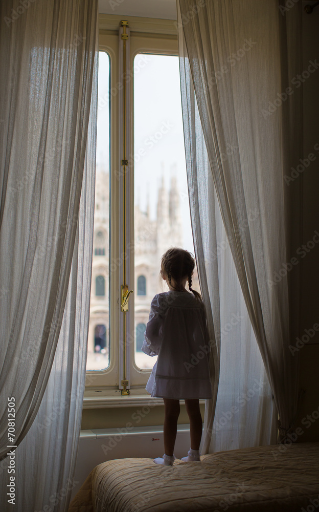 Adorable little girl looking out the window at Duomo, Milan, Adorable little girl looking out the window at Duomo, Milan,