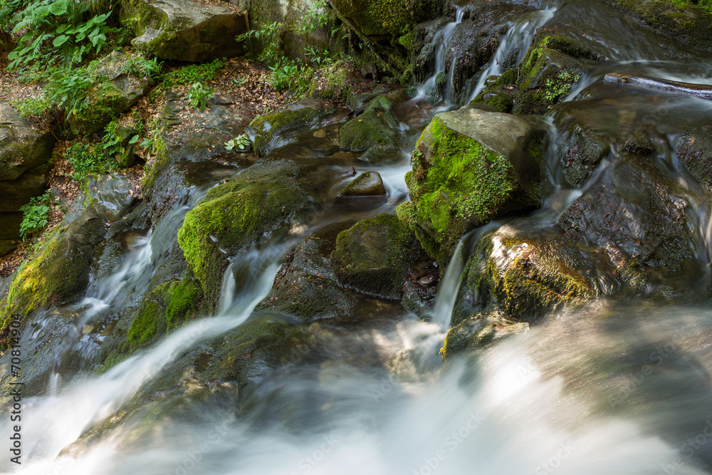 beautiful waterfall comes out of a huge rock in the forest beautiful waterfall comes out of a huge rock in the forest