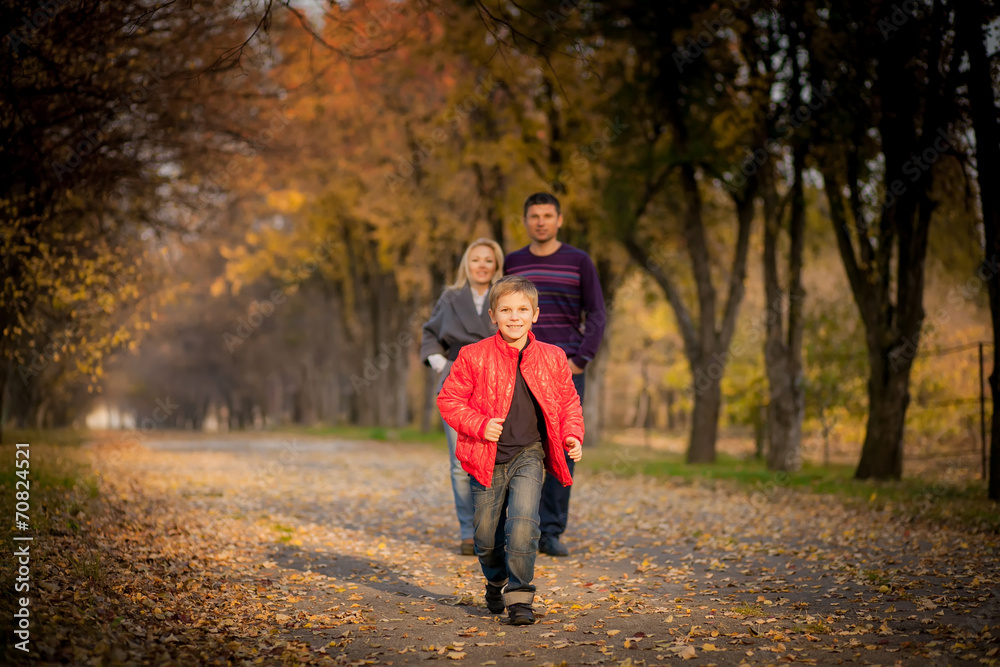 happy boy running ahead of their parents in the park. happy boy running ahead of their parents in the park.