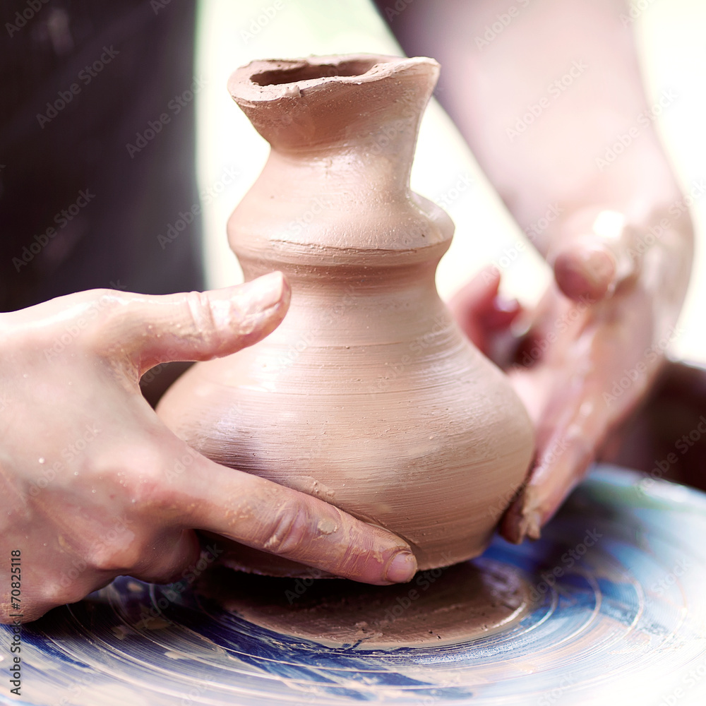 Hands working on pottery wheel Hands working on pottery wheel
