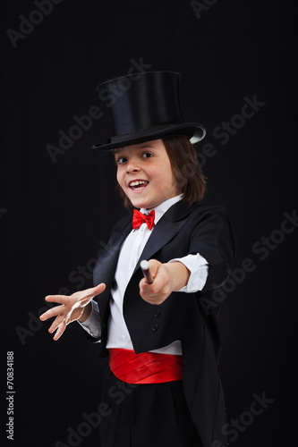 Young magician boy using his magic wand photo