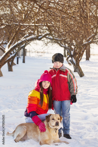 Girl and Boy in Snow Playing with Dog
