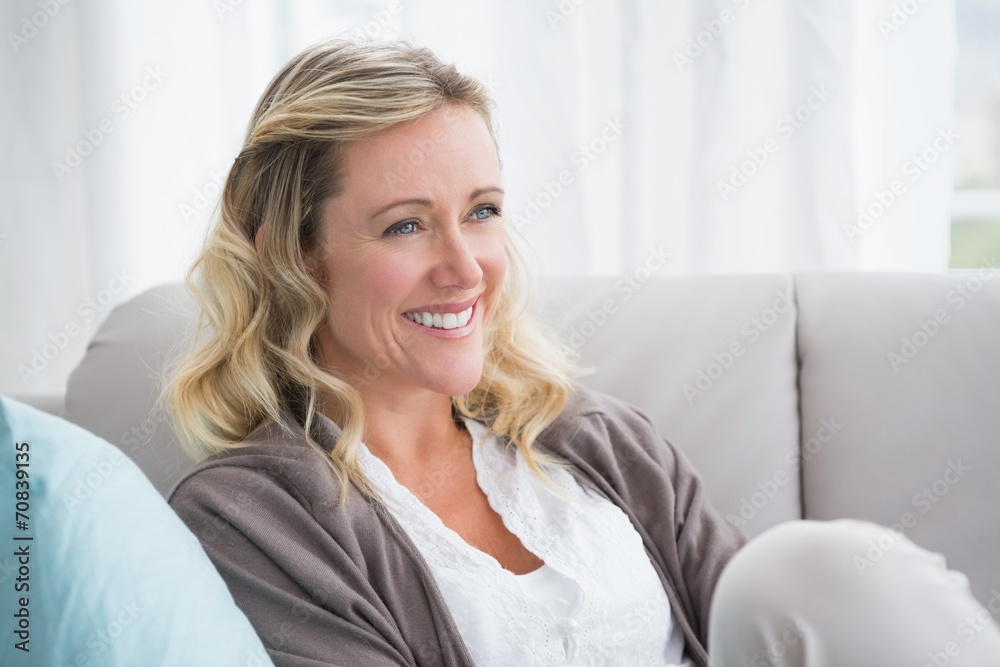 Pretty day dreaming blonde sitting on the couch Pretty day dreaming blonde sitting on the couch