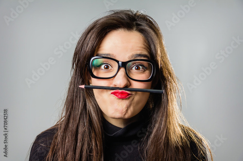 Real girl holding a pencil with her red lips