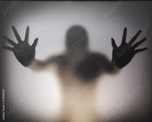 Man standing behind frosted glass