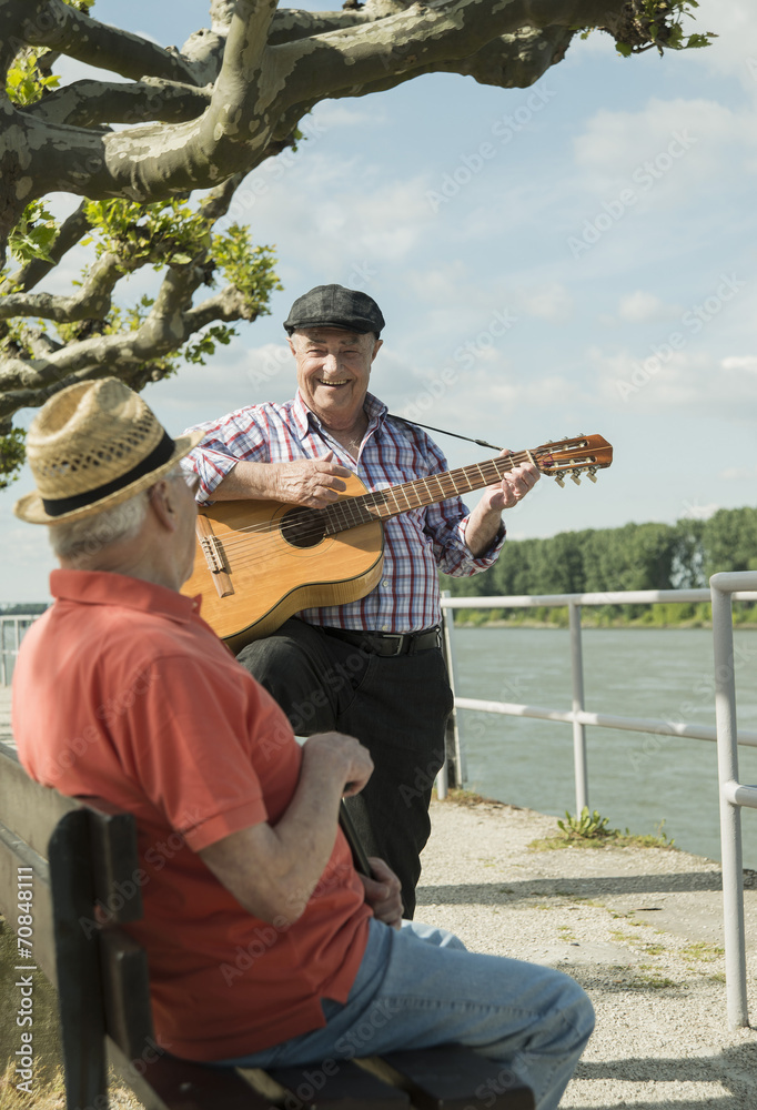 Germany, Rhineland-Palatinate, Worms, two old men with guitar at promenade of Rhine River Germany, Rhineland-Palatinate, Worms, two old men with guitar at promenade of Rhine River