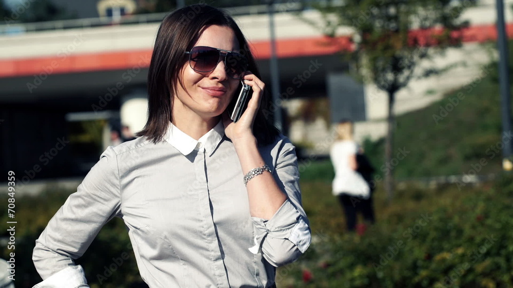 Young attractive businesswoman talking on cellphone in the city