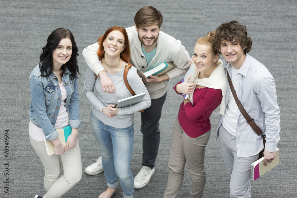 Portrait of confident students holding books Portrait of confident students holding books