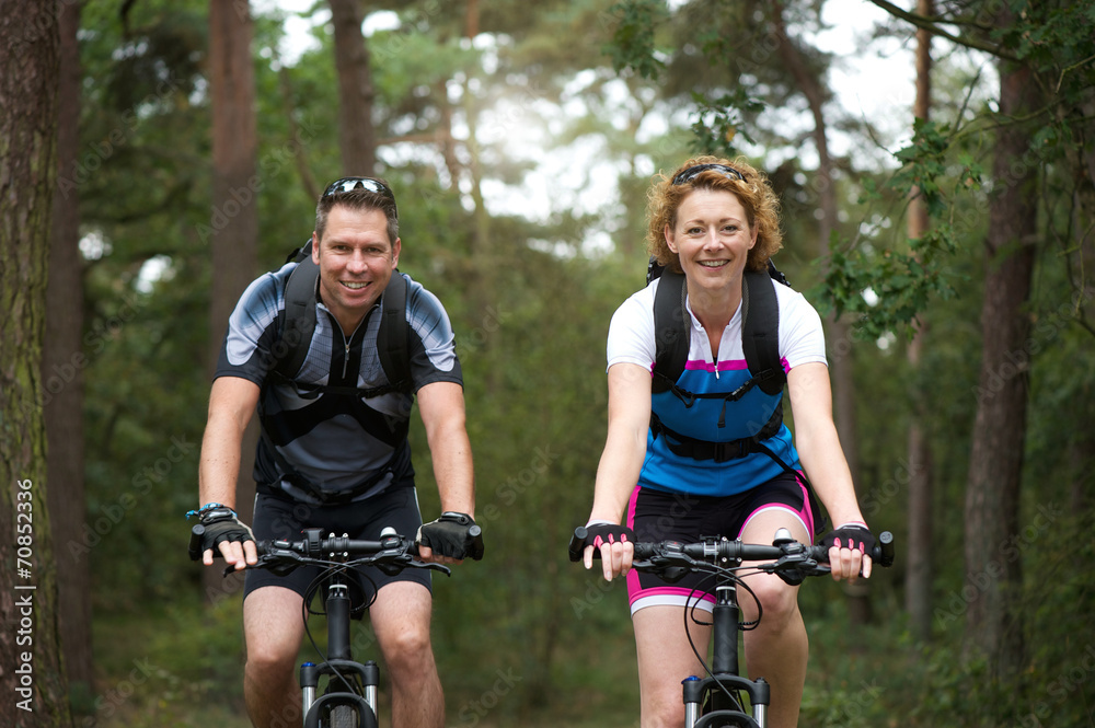 Man and woman cyclist smiling outdoors