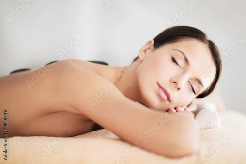 beautiful woman in spa salon with hot stones