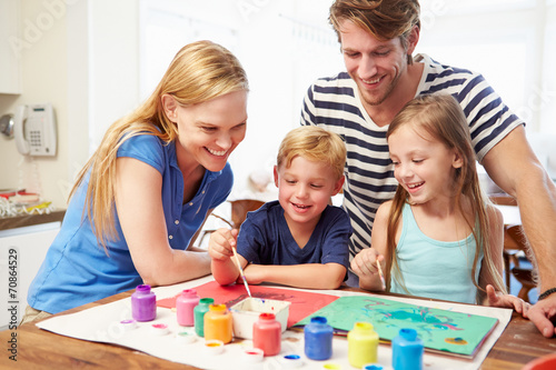 Parents Painting Picture With Children At Home