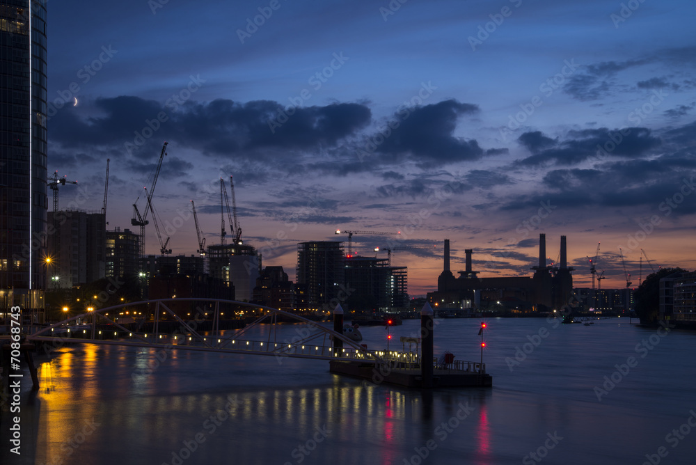 Construction cranes and skylines over sunset in London