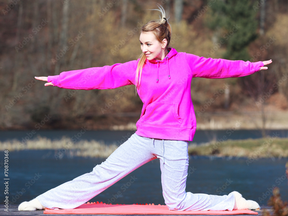 Naklejka premium Woman teenage girl in tracksuit doing exercise on pier outdoor