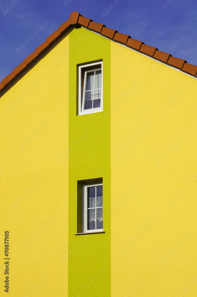 Renovierter Hausgiebel mit PVC Fenstern und Malerdekor