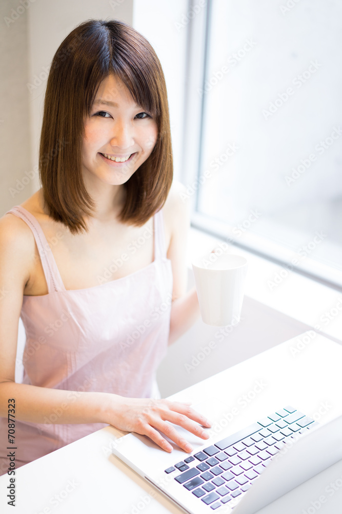 パソコンを使いながらコーヒーを飲む女性 パソコンを使いながらコーヒーを飲む女性