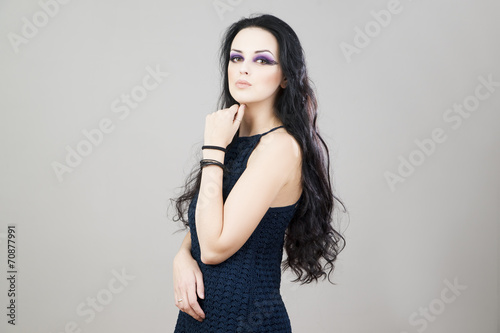 Portrait of a beautiful young woman on a gray background