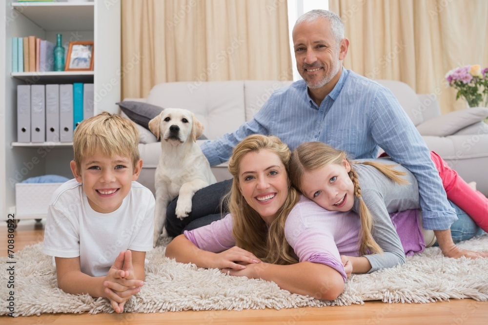 Happy parents and their children on floor with puppy