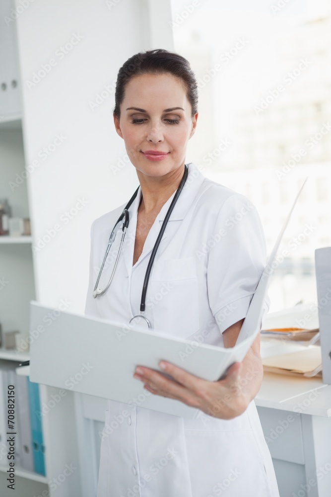 Focused doctor looking at a folder Focused doctor looking at a folder