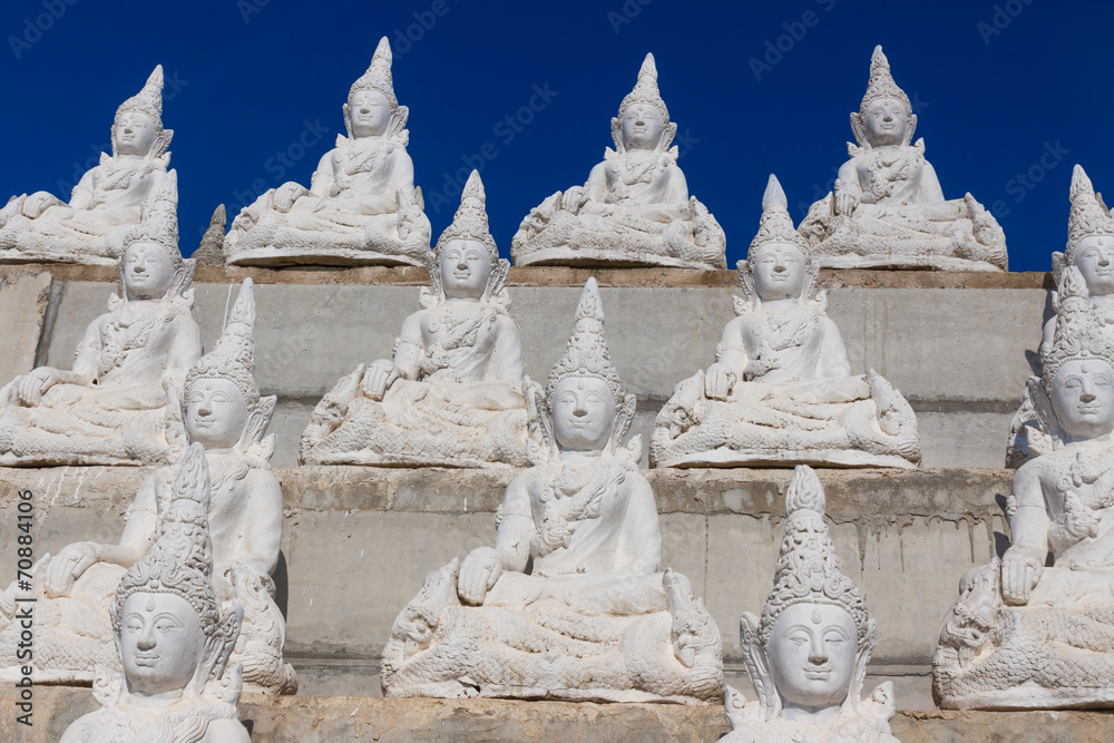 raw of white buddha status on the wall raw of white buddha status on the wall