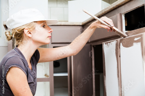 Closeup of Woman Painting Kitchen Cabinets