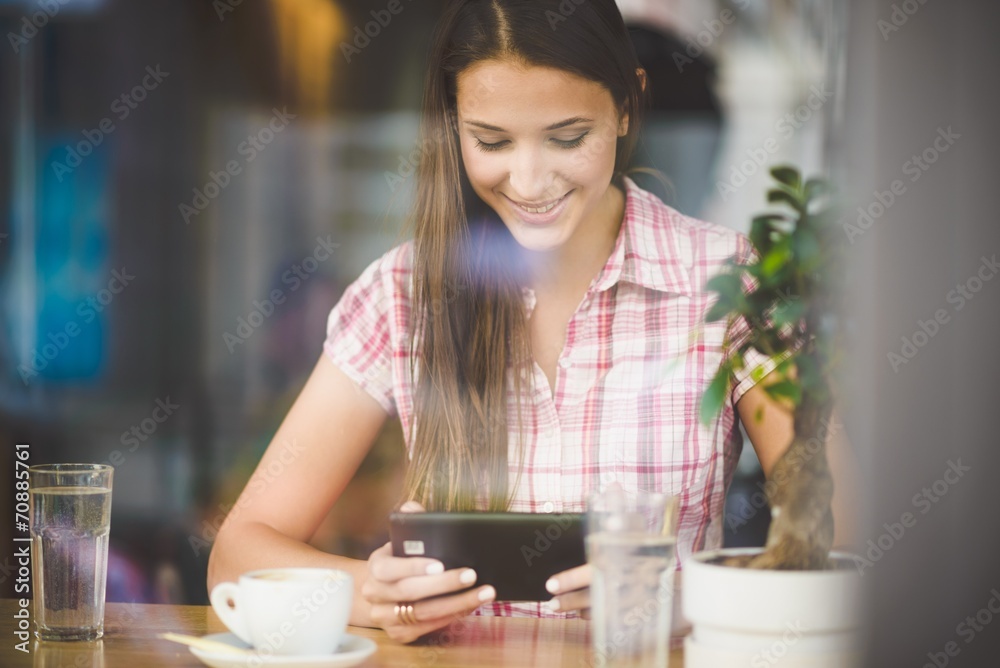Young woman in cafe looking in tablet Young woman in cafe looking in tablet